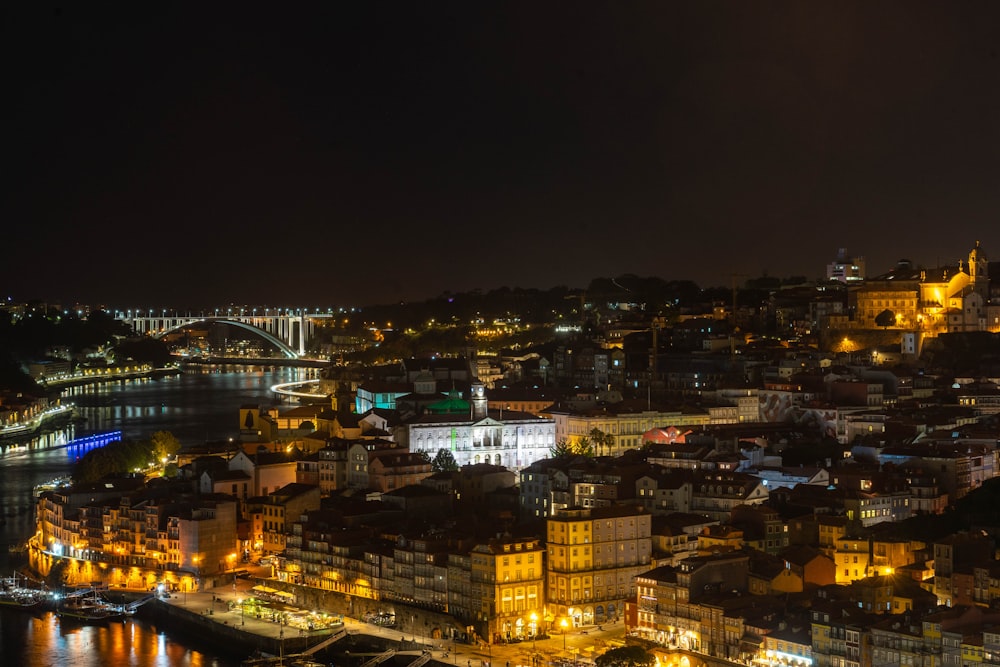 Una veduta di una città di notte con un ponte sullo sfondo
