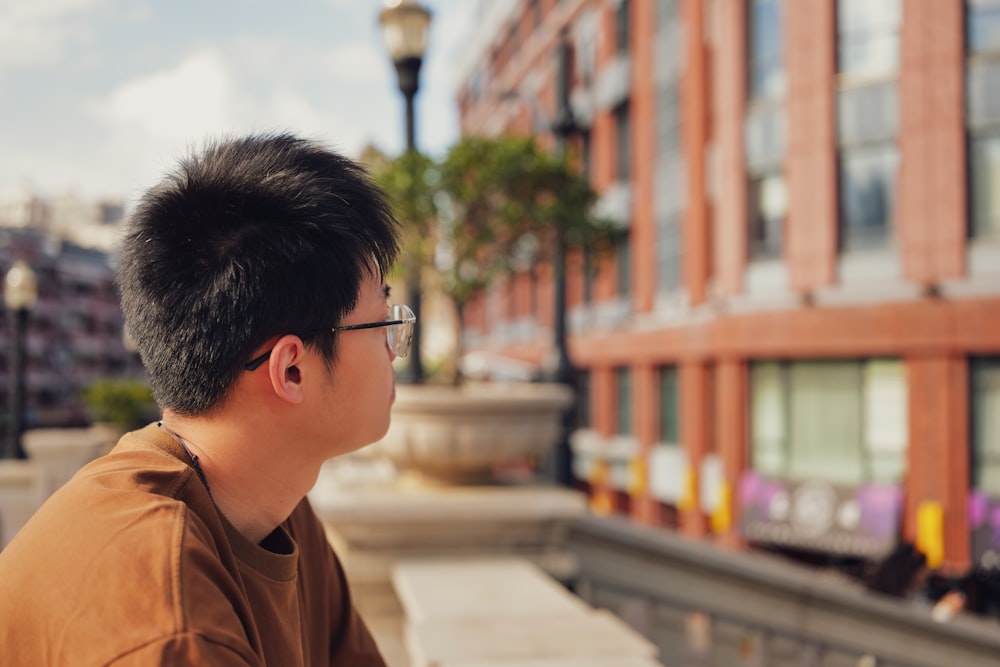 a man wearing glasses sitting on a bench