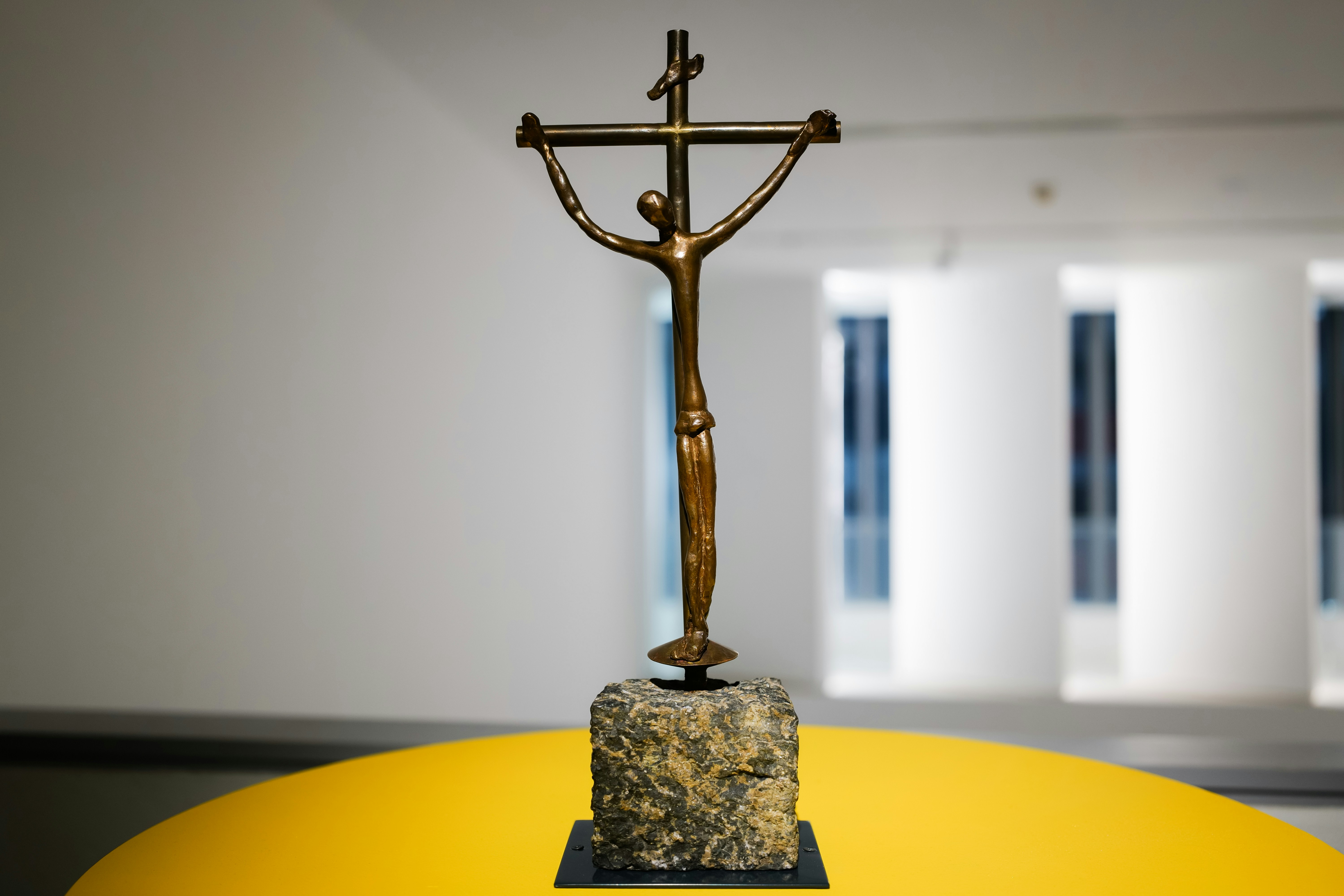 un crucifijo dorado encima de una mesa amarilla