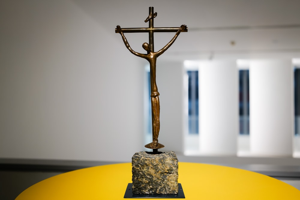un crucifijo dorado encima de una mesa amarilla