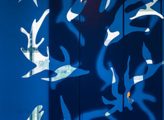 Abstract wall art with playful leaf shapes in bold colors on a rustic wooden background.