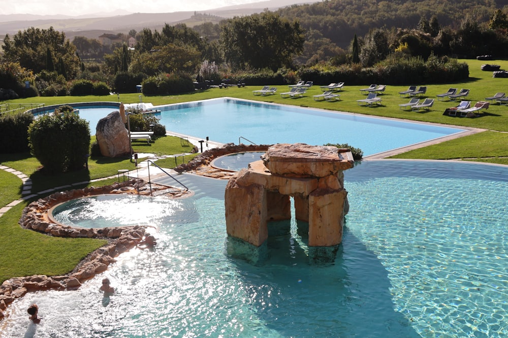 a large swimming pool surrounded by a lush green field