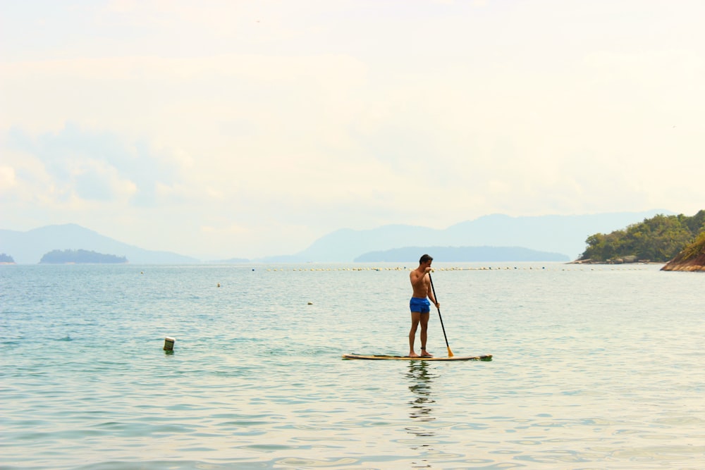 a person standing on a paddle board in the water