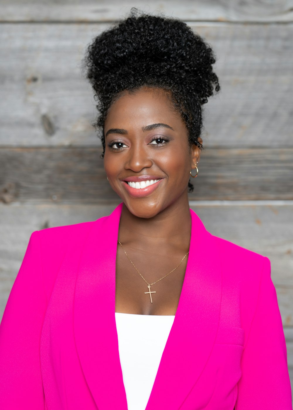 a woman in a pink jacket smiling for the camera