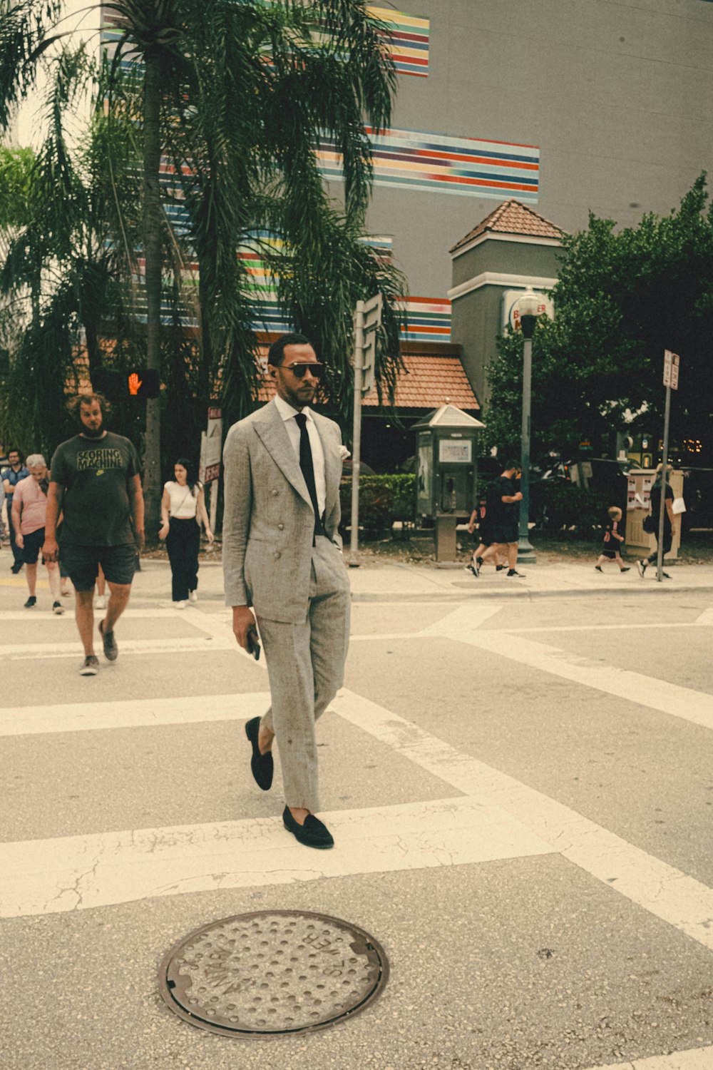 a man in a suit walking across a street