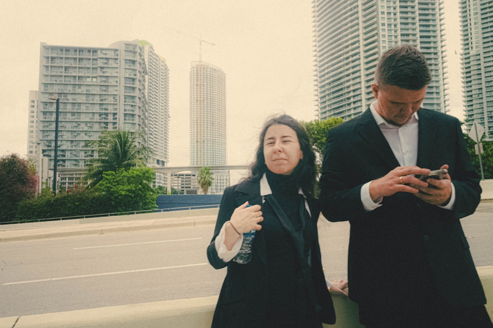 a man and a woman looking at a cell phone