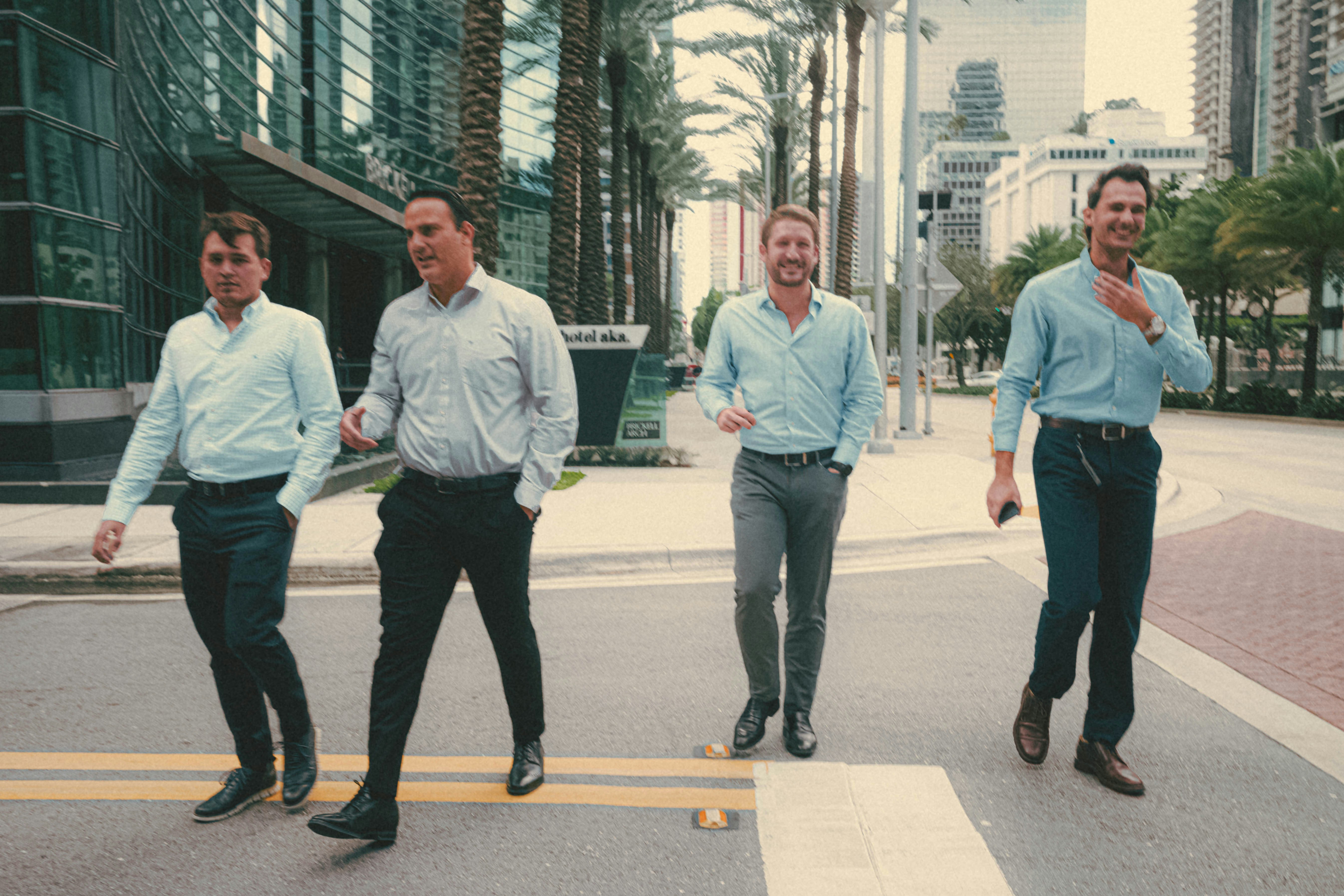 a group of men walking across a cross walk