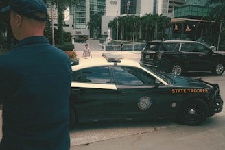 a man standing in front of a police car