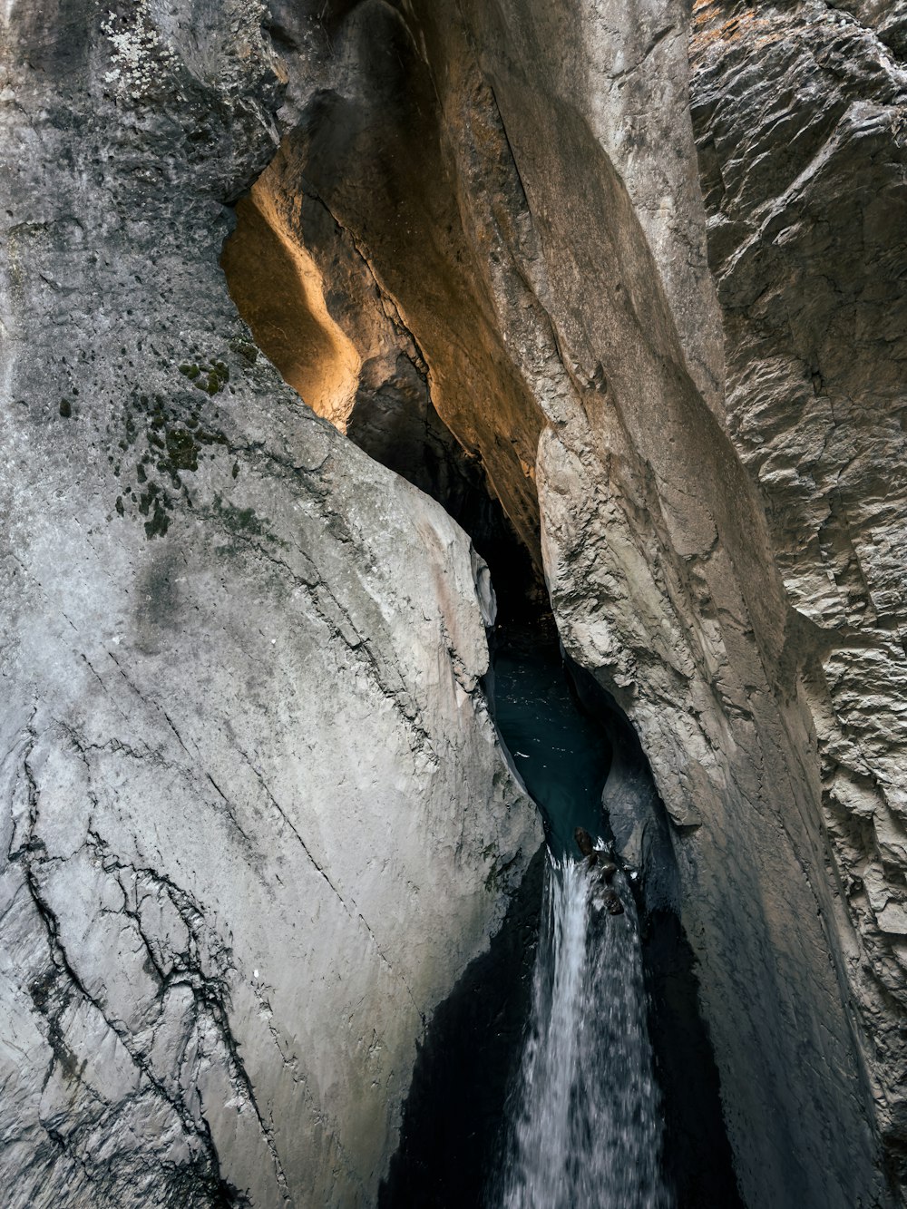 a man standing on a waterfall in the middle of a canyon