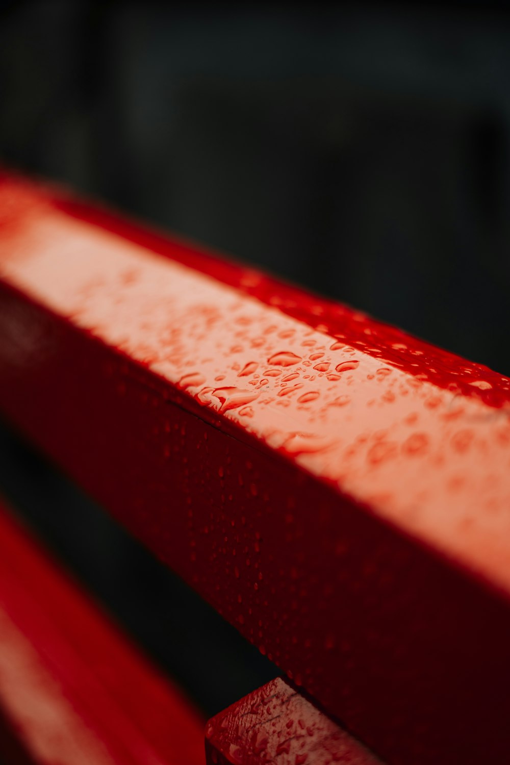 a red bench with water drops on it