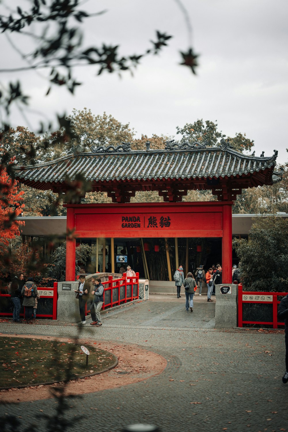 a group of people standing in front of a red building