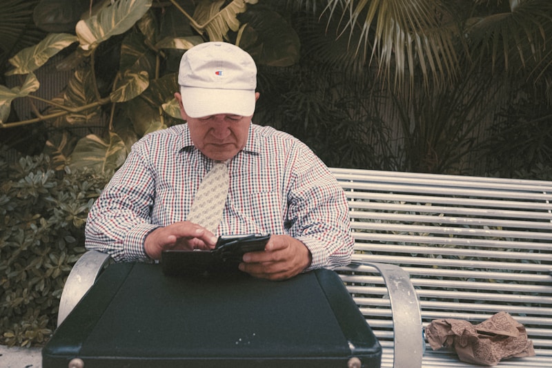 a man sitting on a bench looking at his cell phone