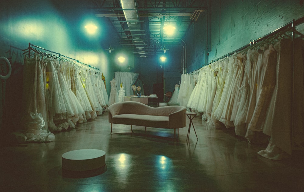 a room filled with lots of white dresses