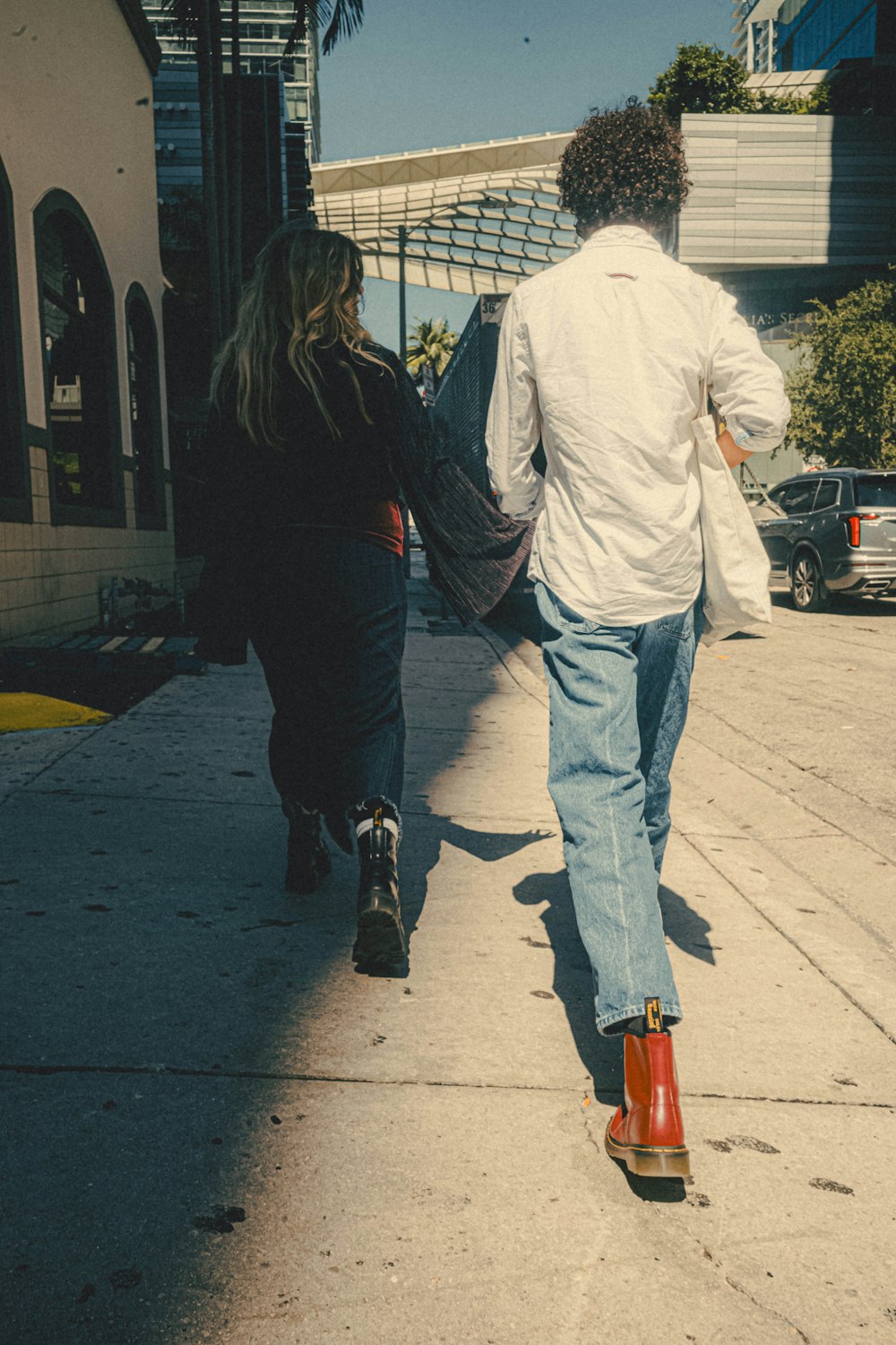 a man and a woman walking down a sidewalk