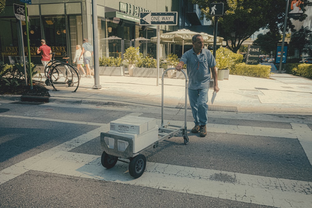 a man pushing a cart across a street