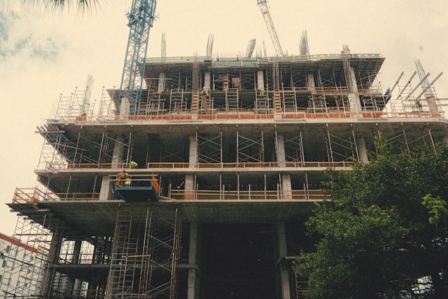 Modern construction site with cranes and workers in safety gear