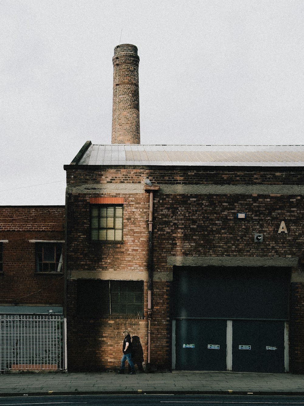 two people standing in front of a brick building