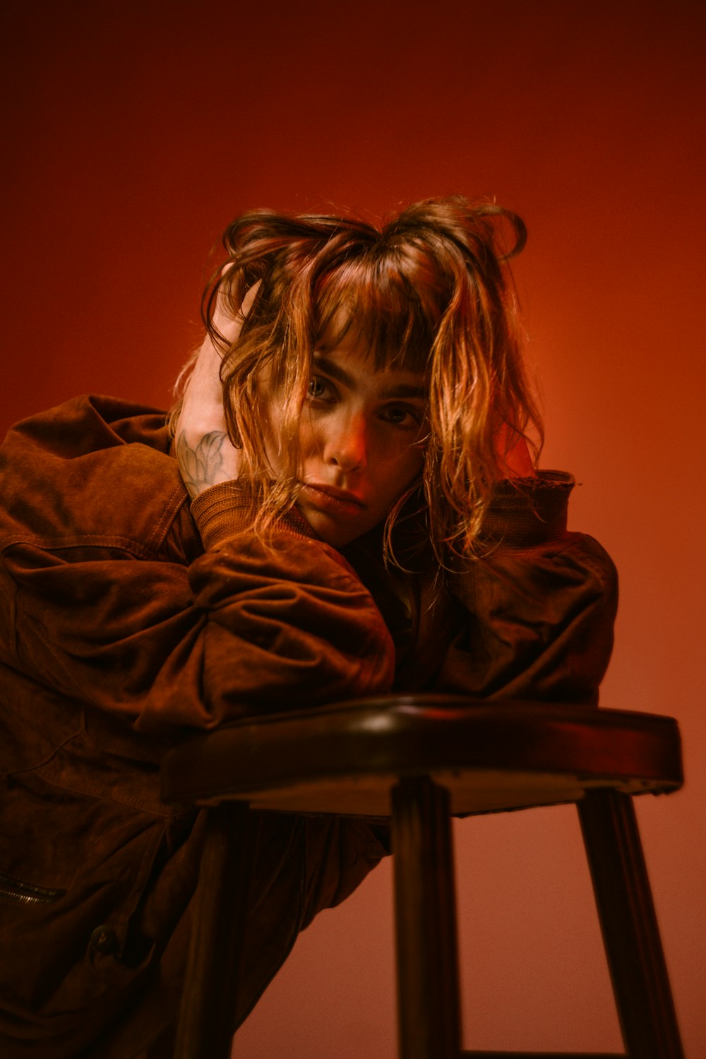 a woman sitting on top of a wooden stool