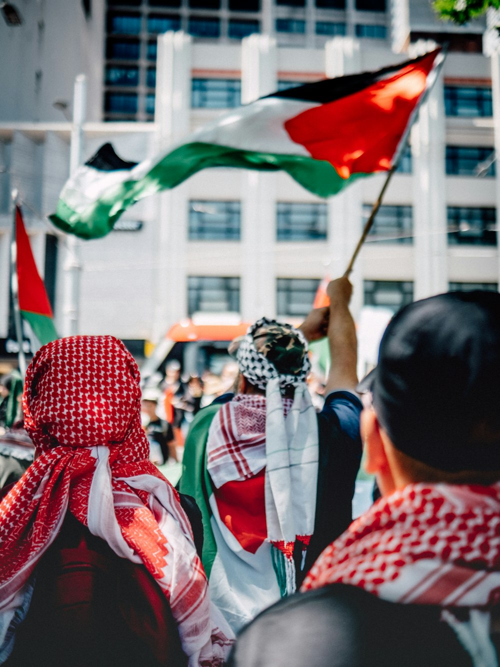 a group of people holding flags in front of a building