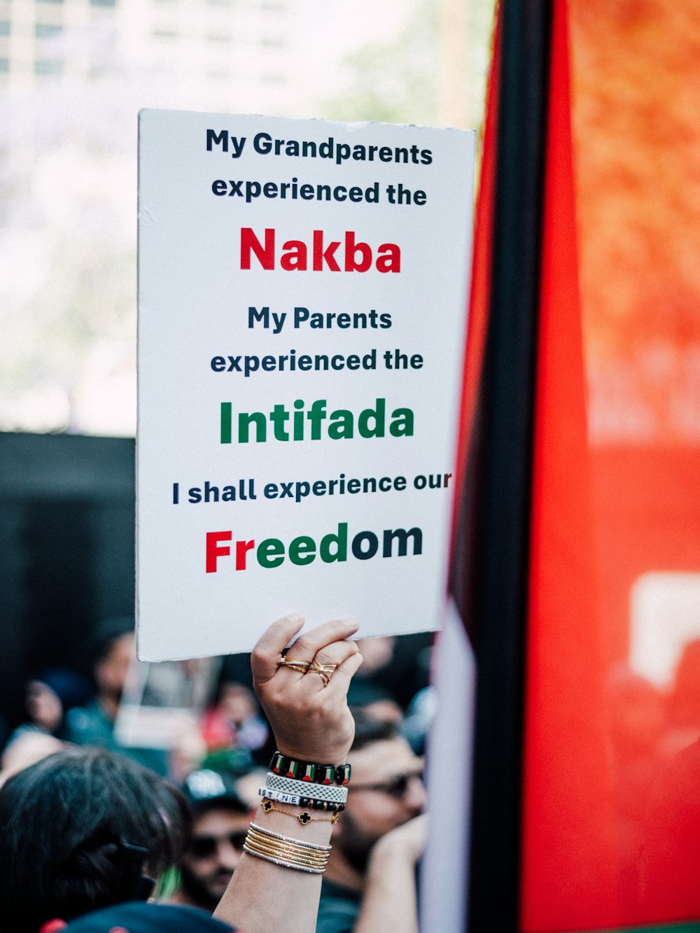 a person holding a sign in front of a crowd