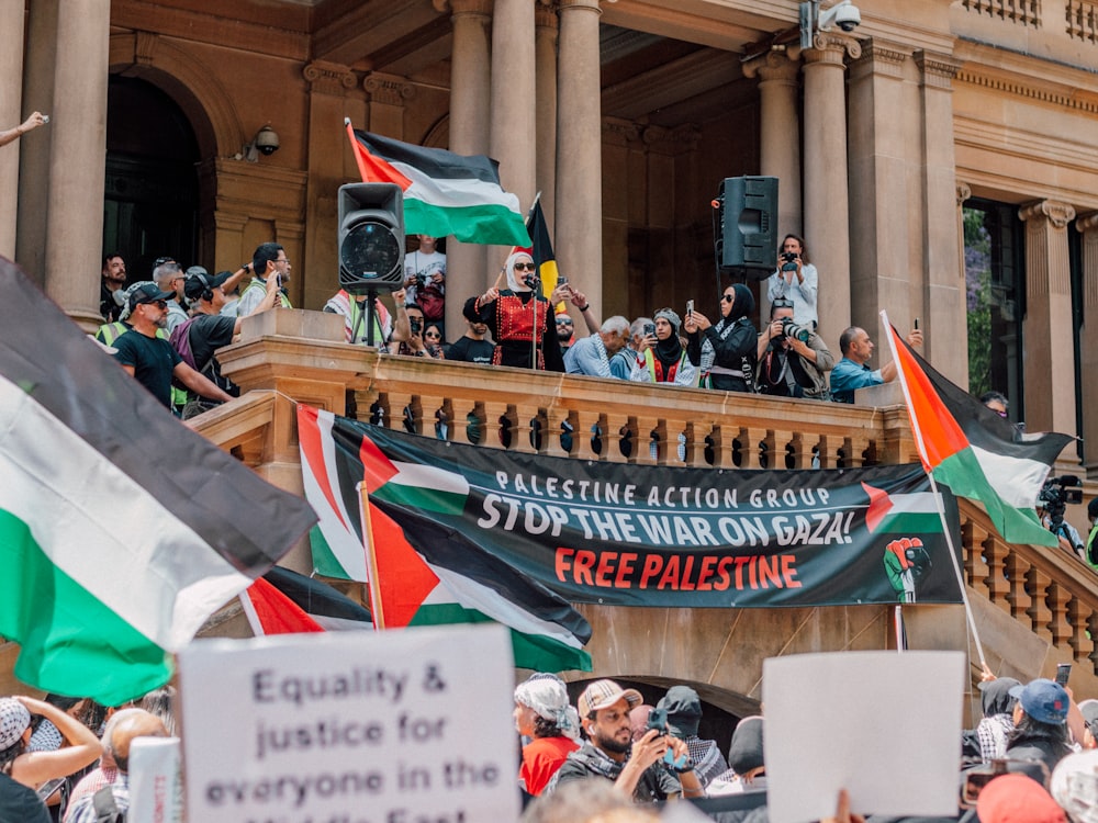 a large group of people holding flags and banners