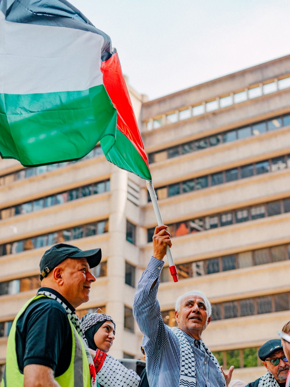 a group of people holding a flag in front of a building