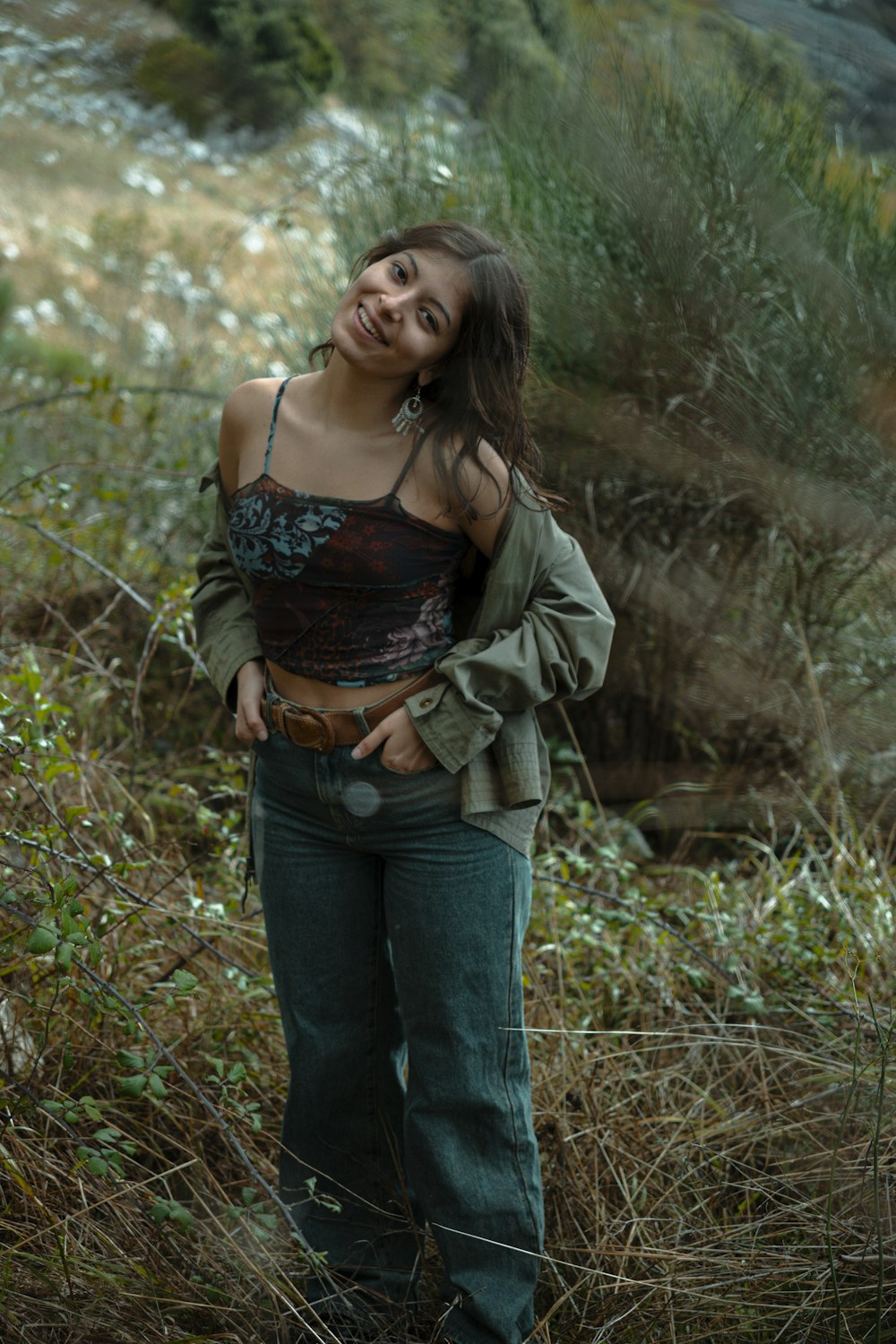 a woman standing in a field with her hands on her hips