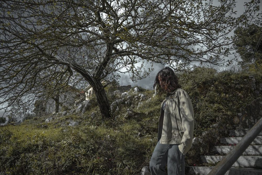 a woman standing in front of a tree