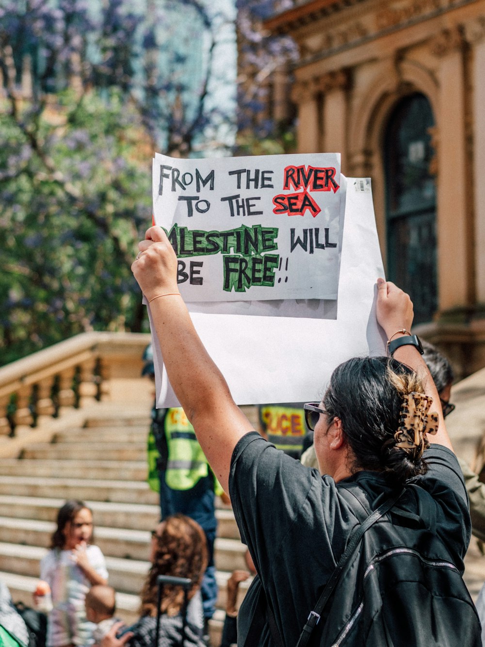 a man holding a sign that says from the river to the sea