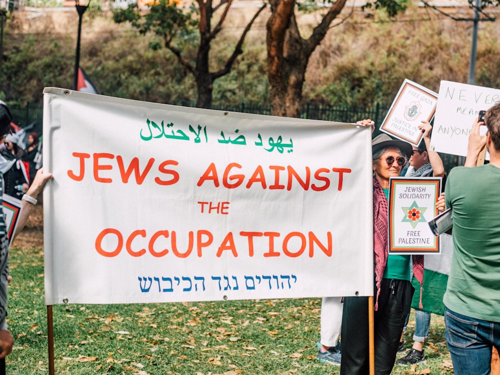 a group of people holding signs in a park