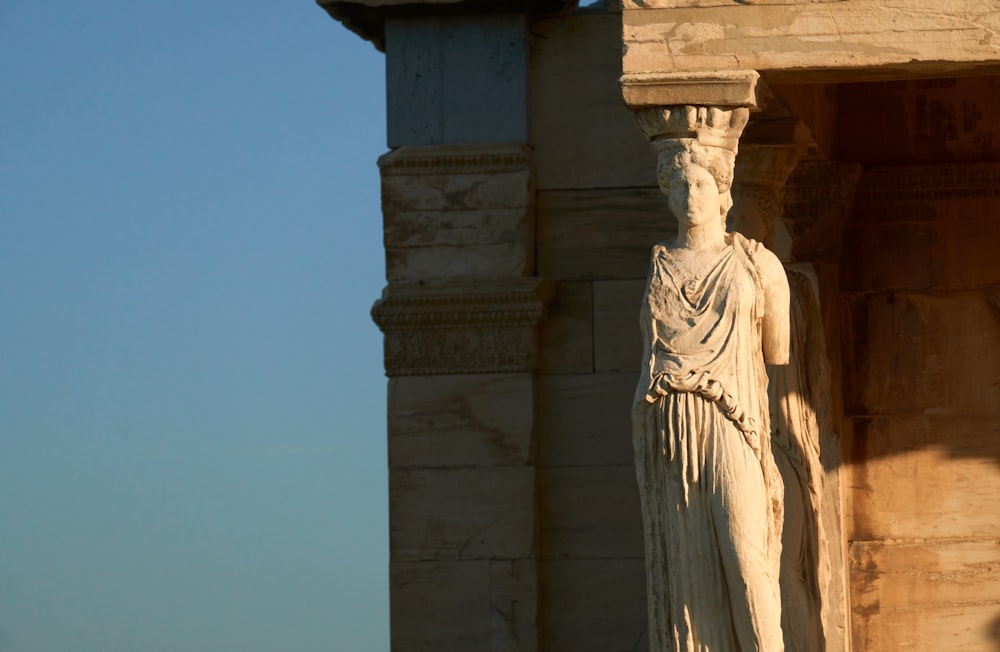 a statue of a woman standing next to a building