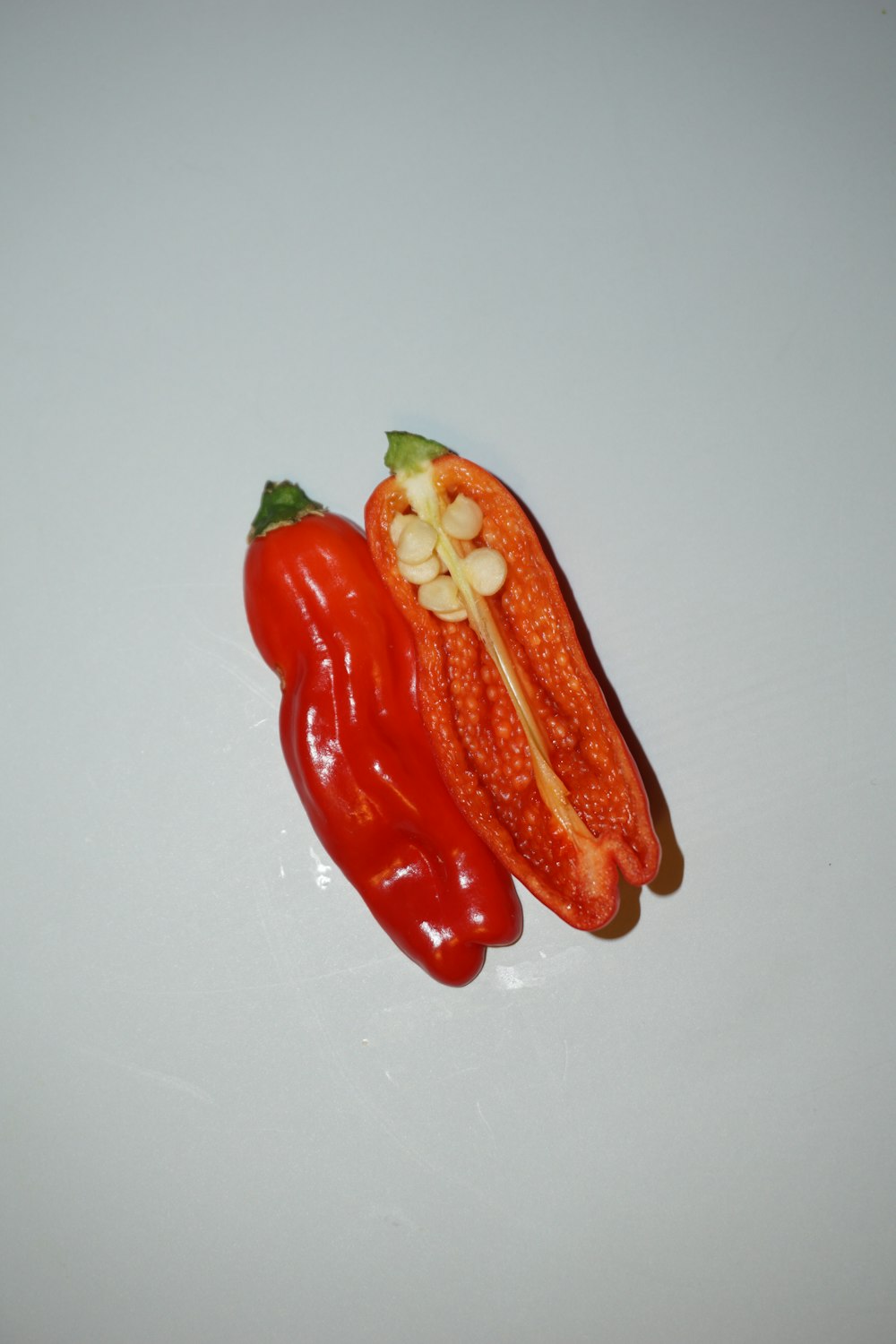 a red pepper sitting on top of a white table