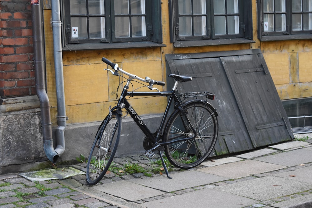 a bicycle leaning against a building on a sidewalk