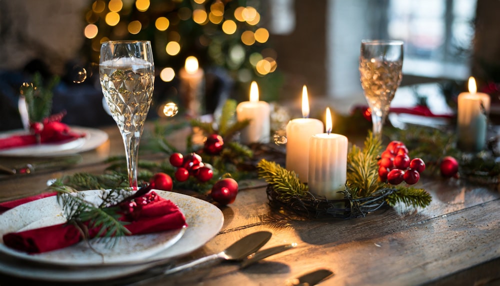 a wooden table topped with plates and candles