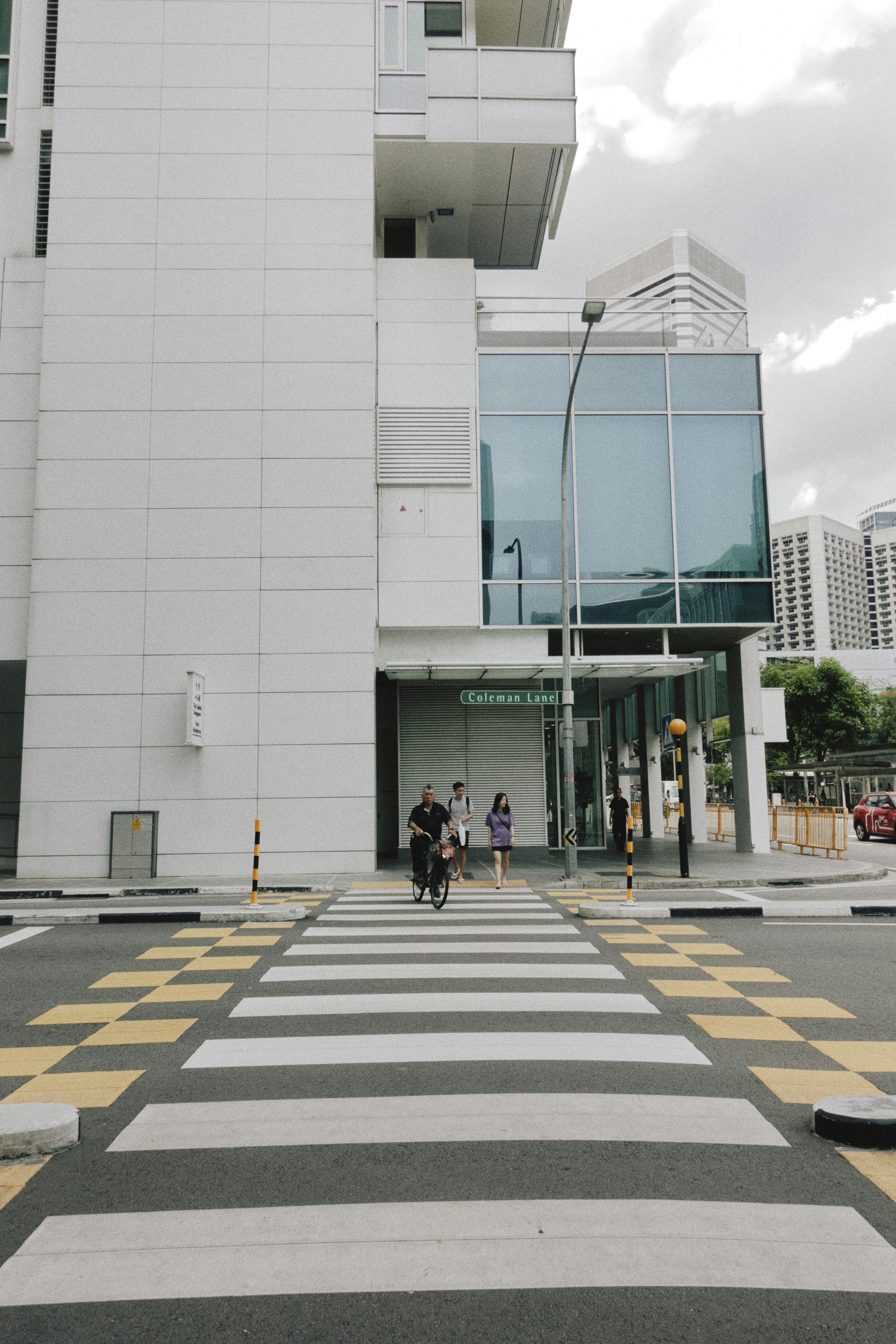 a person riding a bike down a street next to a tall building