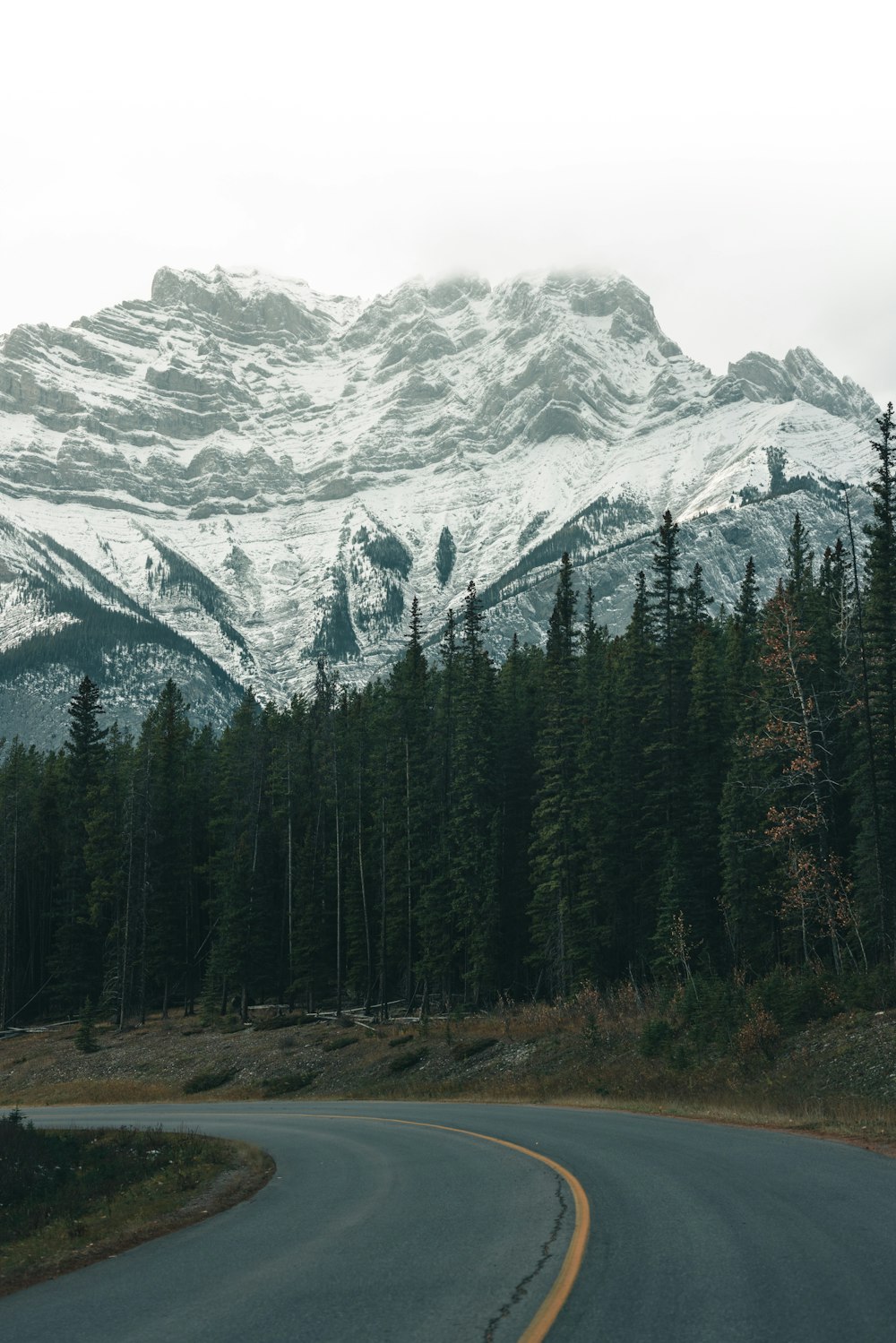 a winding road with a mountain in the background