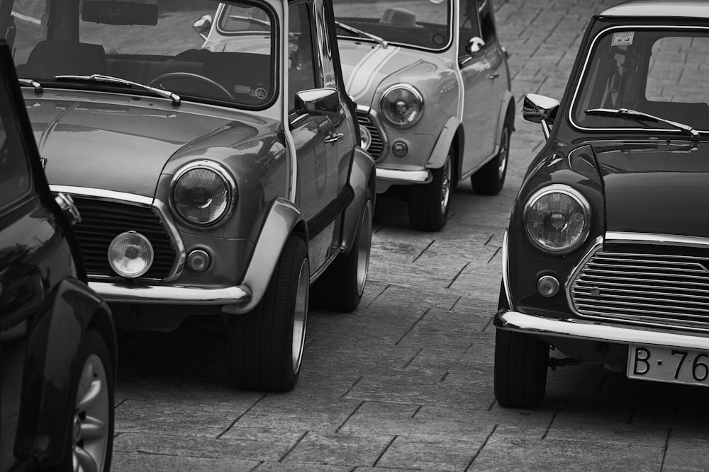 a black and white photo of a row of old cars