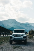 A spacious white SUV parked near a scenic mountain road.