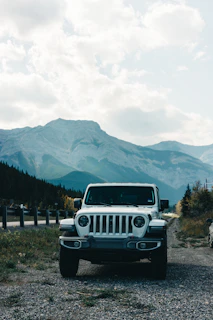 A spacious white SUV parked near a scenic mountain road, ideal for family trips.