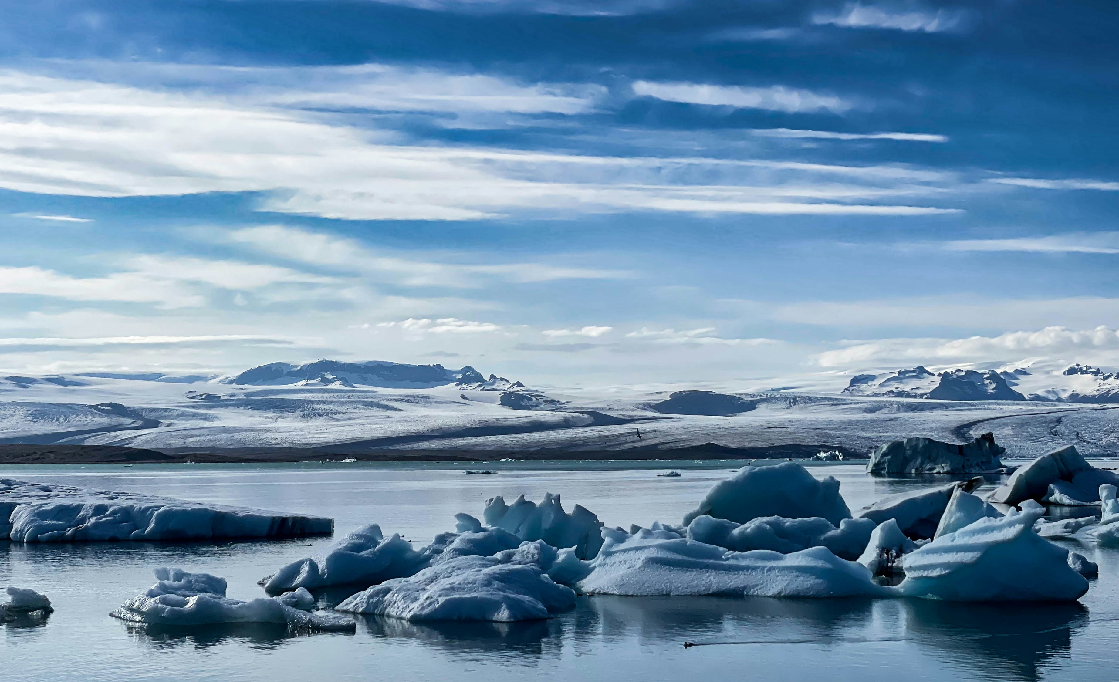 A group of icebergs floating on top of a lake photo – Free Útsýni yfir
