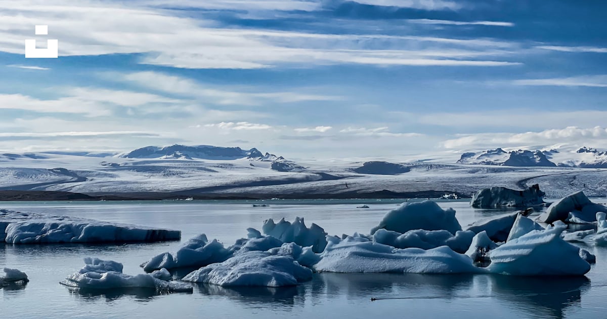 A group of icebergs floating on top of a lake photo – Free Útsýni yfir