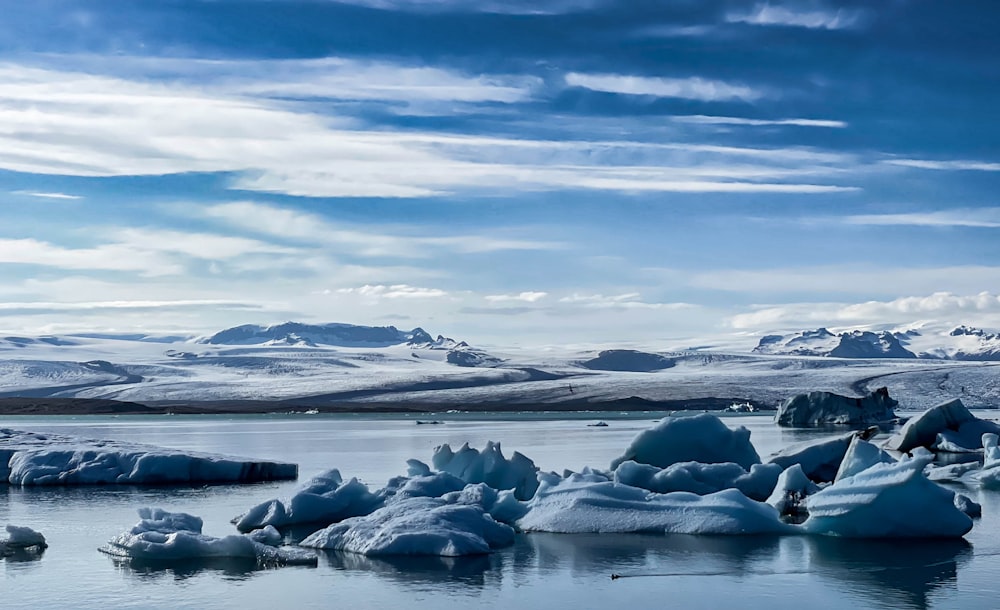 a group of icebergs floating on top of a lake