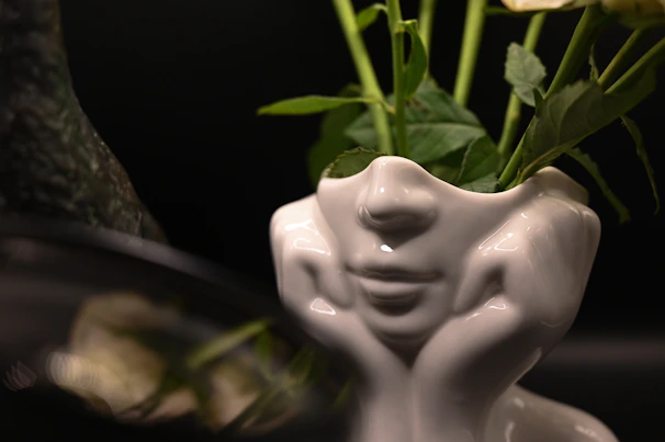 Close-up of a personalized porcelain vase with intricate details and a fresh green plant