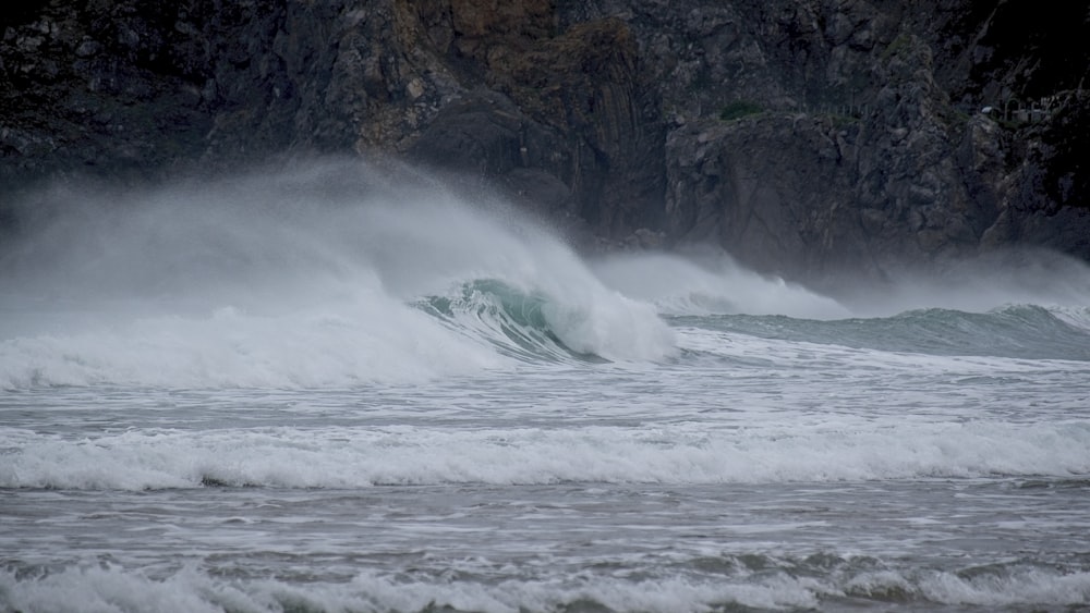 a large wave crashing into the shore of the ocean