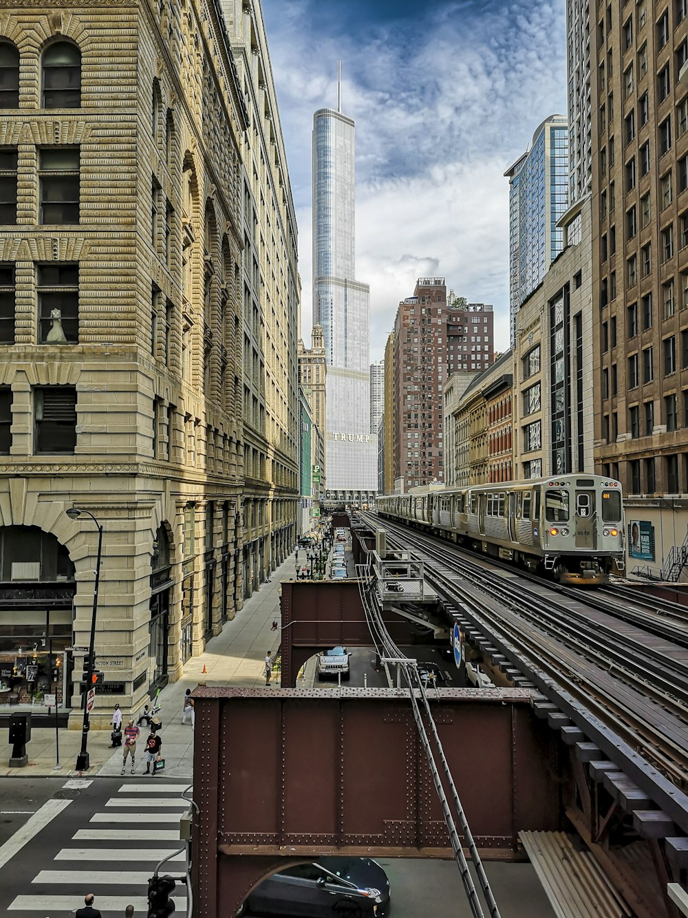 um trem viajando por uma cidade ao lado de edifícios altos