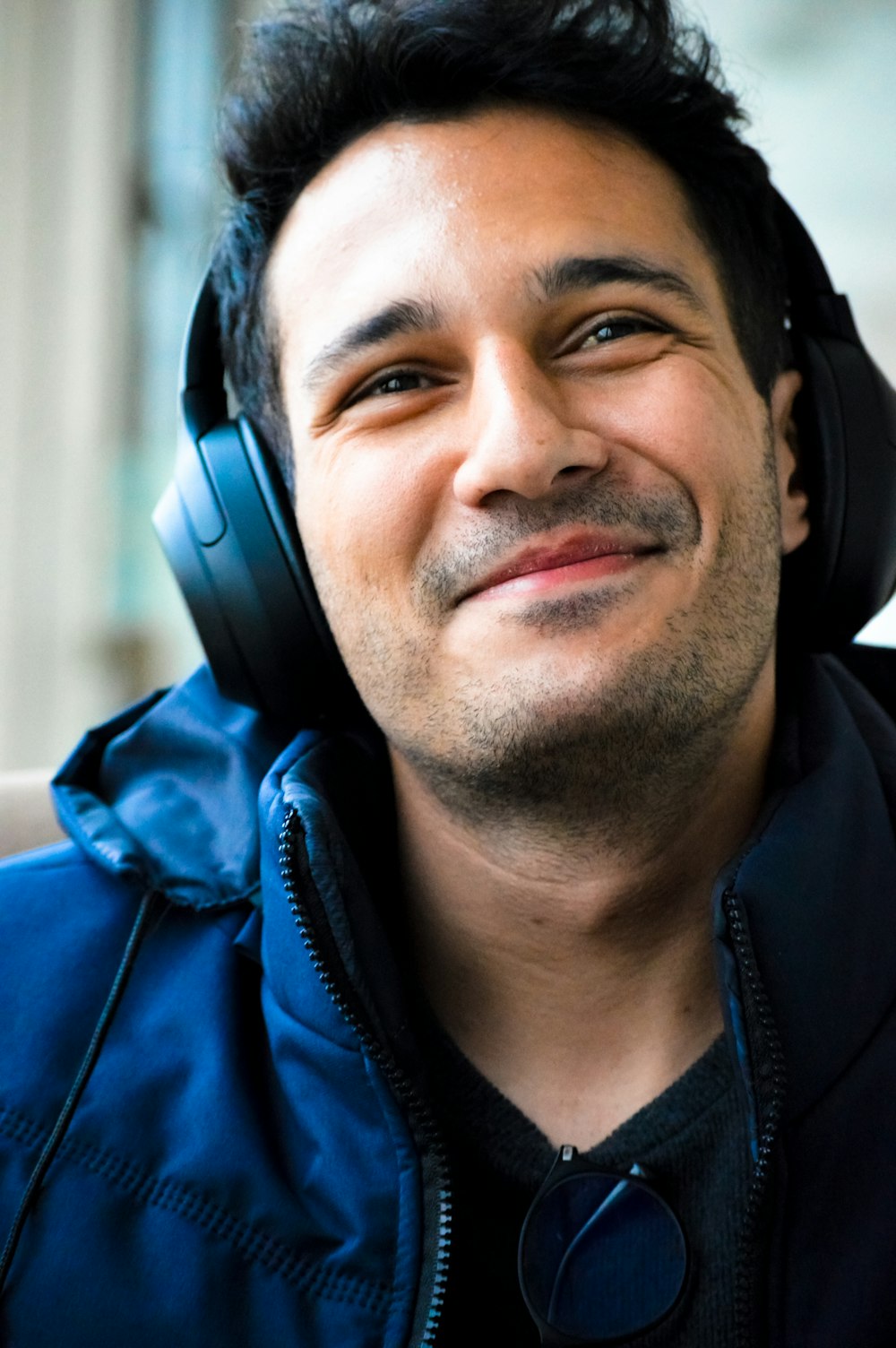 Un homme avec des écouteurs souriant pour la caméra