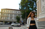 Editorial style photo of a woman wearing a chic nude blazer and black pants in an urban setting.