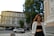 A stylish woman wearing a tailored blazer, standing confidently in an urban setting.