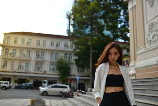 A stylish woman wearing modern, elegant women's clothing in a bright, urban setting.