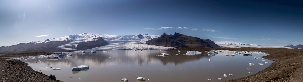 a large body of water surrounded by snow covered mountains